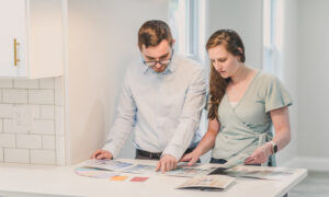 A couple consider paint samples after purchasing their first home