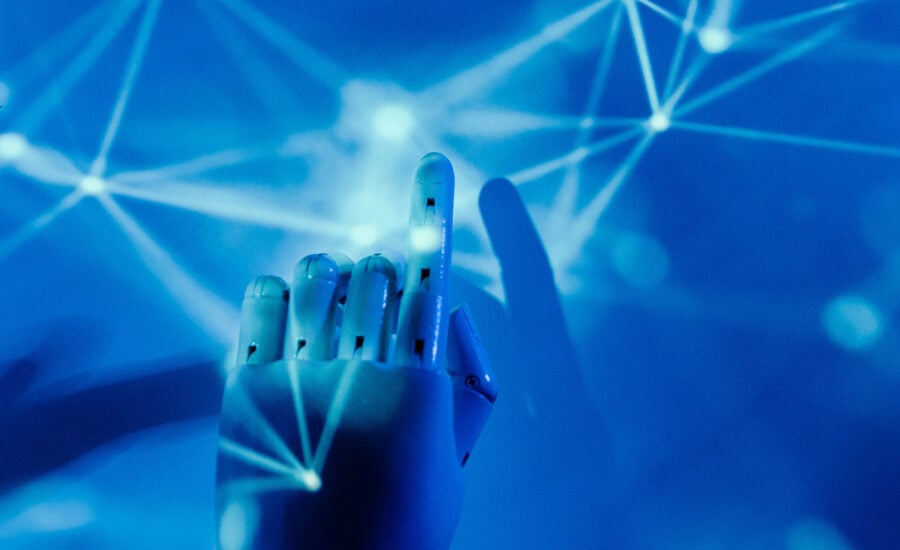 A robotic hand touches lines of light to symbolize robo-advisor with a human touch.