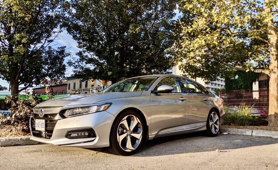 A silver Honda Accord in a parking lot surrounded by trees