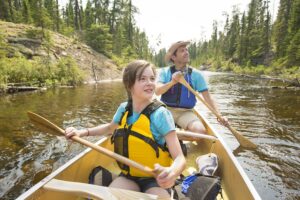 A young girl and her dad in a canoe on a river