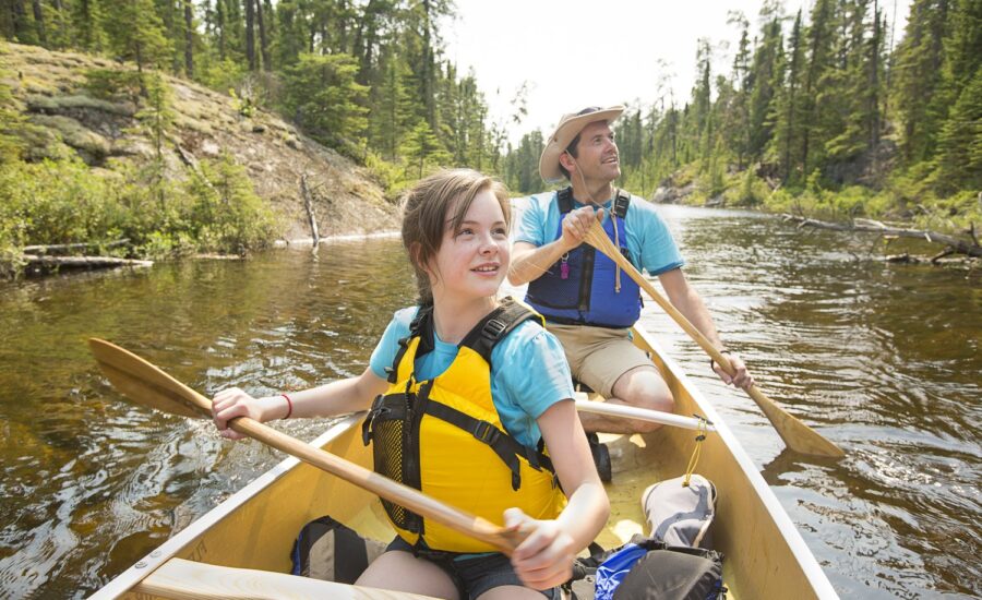 A young girl and her dad in a canoe on a river