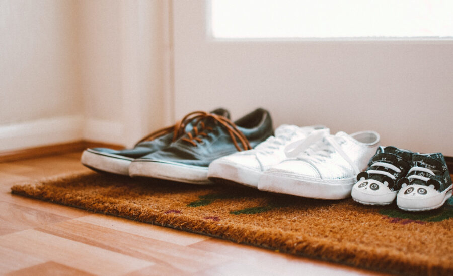 Three pairs of shoes are nicely placed in the entryway of a home