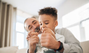 A man in his late 50s is having some fun with his grandson, showing a snapshot of what retirement may be like and how annuities will matter.