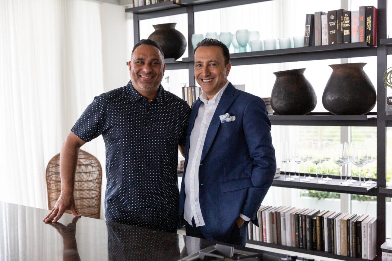 Russell Peters is pictured next to business partner Simon S. Mass as while behind a book shelf.