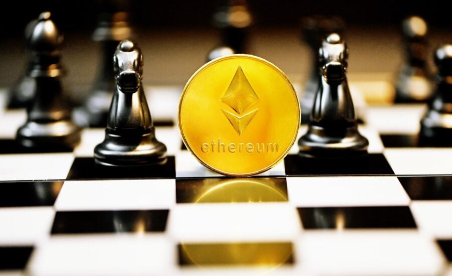 A gold coin with an Ethereum logo sits on a chess board