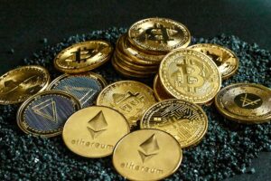 A pile of gold coins with different cryptocurrency logos