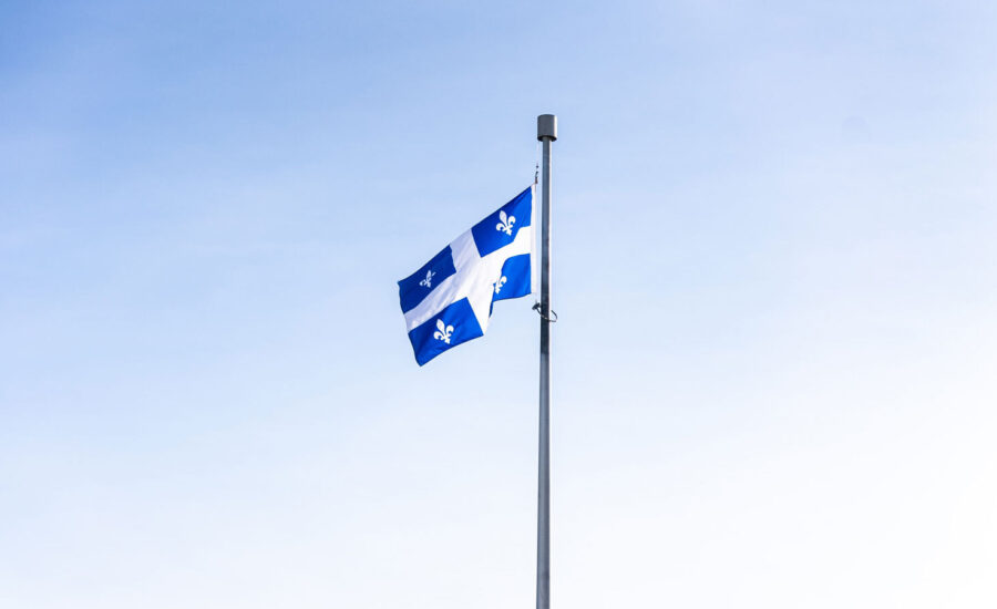 A Quebec flag on a pole is seen blowing in the wind