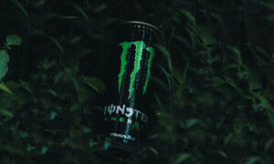 A can of Monster Energy drink coming out of darkness to symbolize its stealth growht