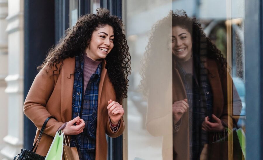 a young woman looks into a store window