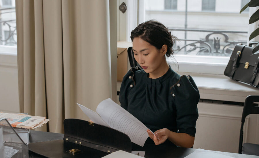 A woman is sitting in a lawyer's office reading a power of attorney document, and she is wondering what the fees are for a POA in Ontario.