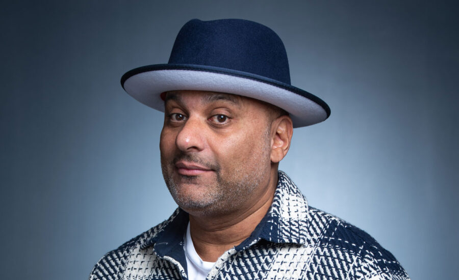 Russell Peters smiles wearing a hat. He chats with MoneySense about investing in real estate.