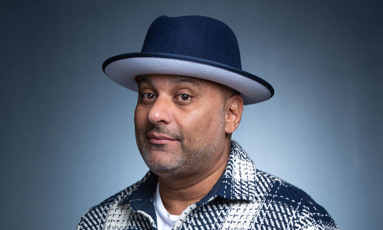 Russell Peters smiles wearing a hat. He chats with MoneySense about investing in real estate.