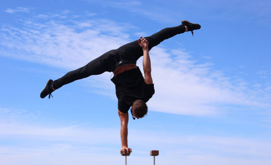 A man doing acrobatics to symbolize the balance needed to calm inflation and a recession.