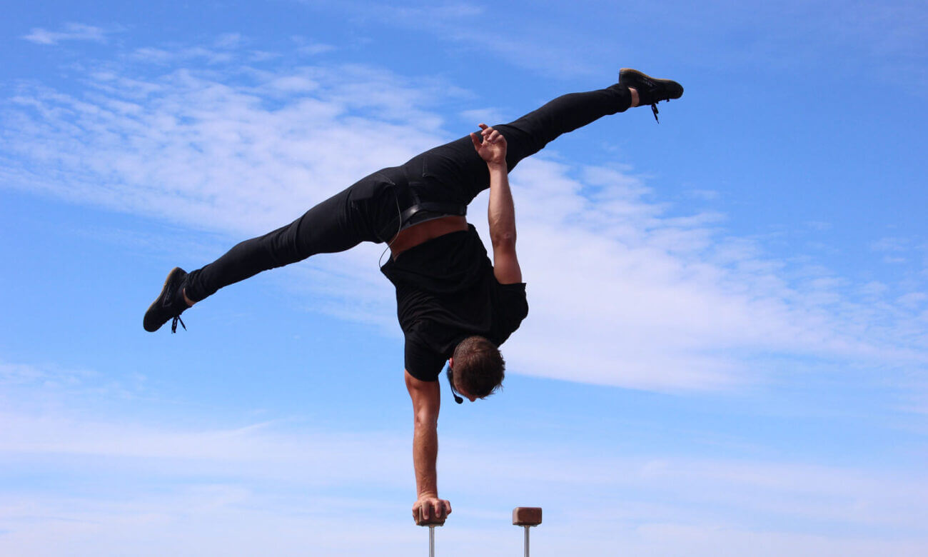 A man doing acrobatics to symbolize the balance needed to calm inflation and a recession.