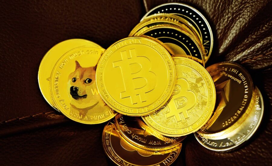 A pile of gold coins with bitcoin and other crypto logos