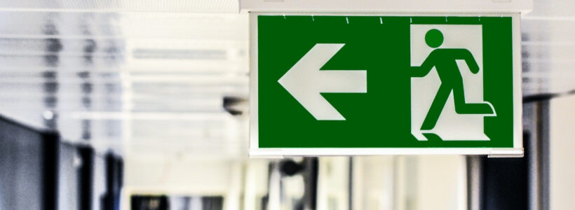 A hallway's exit sign that illustrates a home buyer's decision to break out of a real estate deal