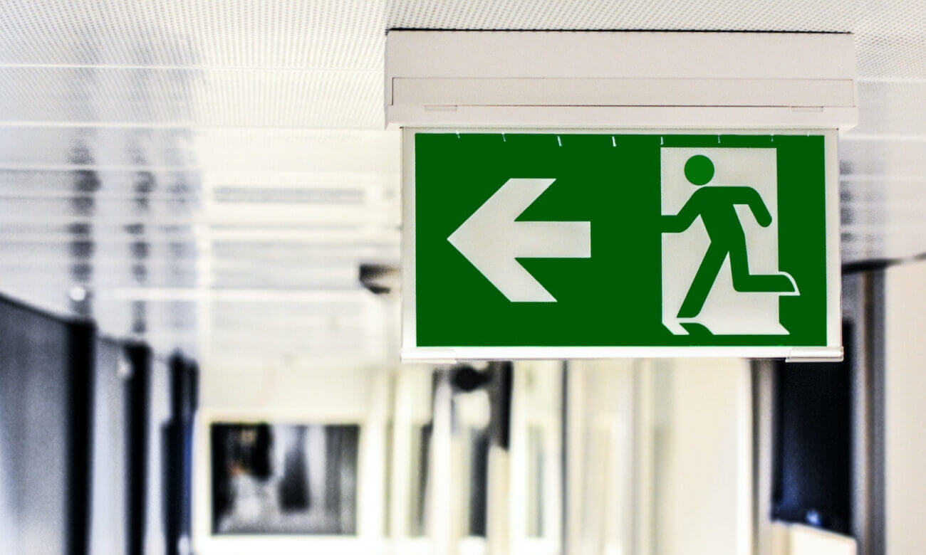A hallway's exit sign that illustrates a home buyer's decision to break out of a real estate deal
