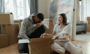 A couple are looking at a photo book, as they clear up the home of a family member. They're also at the stage of wondering the next steps, including who will pay for the mortgage