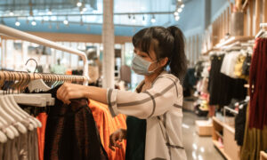 A woman is seen shopping for clothes as she tries to get a deal