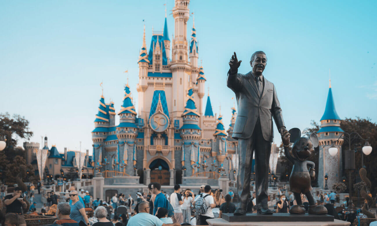 Disney castle at Disneyland is show, with a statue of a proud Walter Disney in front. The company released its earnings this week.