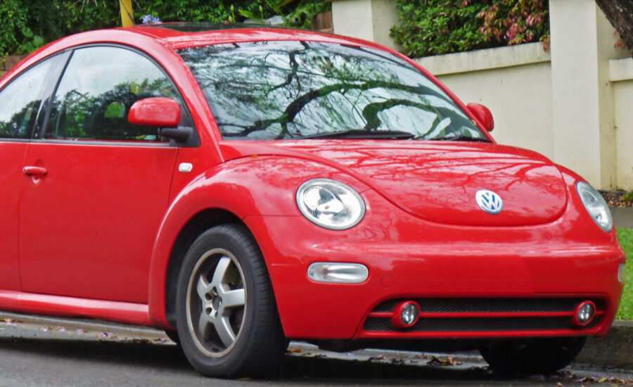 A red Volkswagen Beetle parked on a street