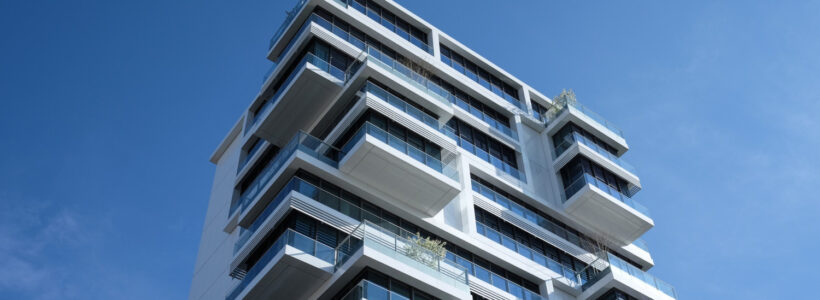 A modern condo building against the backdrop of a clear blue sky