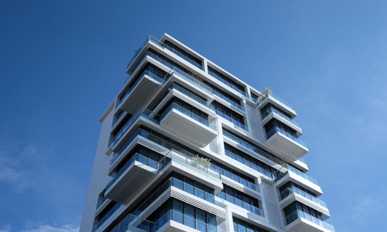 A modern condo building against the backdrop of a clear blue sky