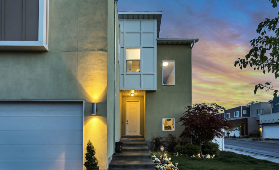 Lights glow in front a modern two-storey home at dusk