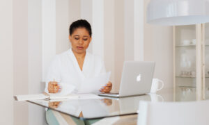 A woman wearing a blazer reviews papework related to the expenses of her second property