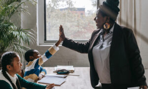 A teacher high-fives one of her students in class after learning about her options for early pension withdrawal