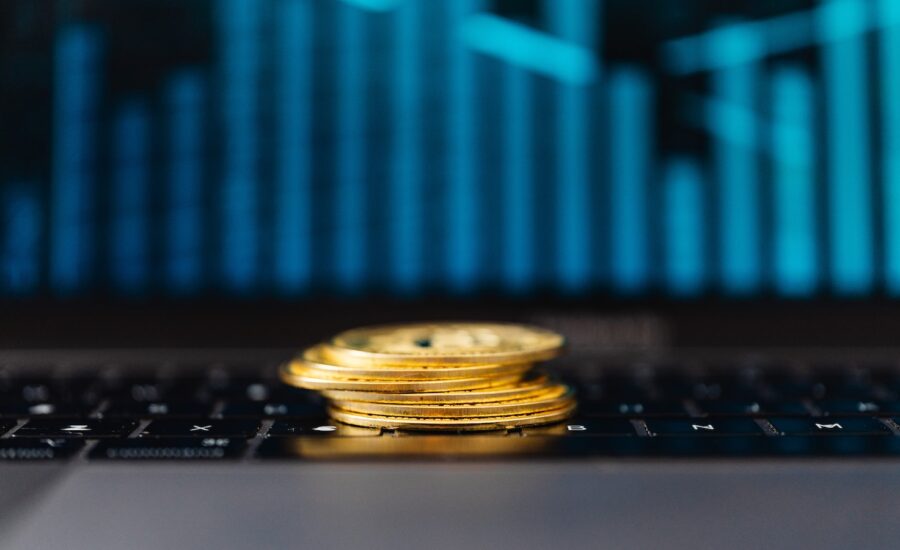 A small pile of gold coins sits in front of a bar graph