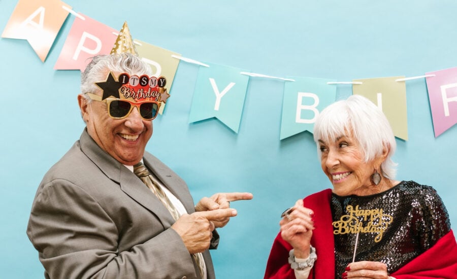 A senior-age couple in party clothes celebrate a birthday