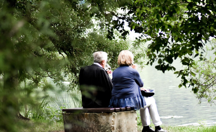 A couple sit together on a bench, discussing how to withdraw from savings with tax efficiency.