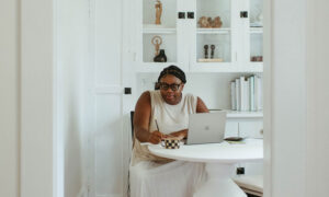A woman sits at her at-home office, prepping her tax return, looking at the 2022 credits she may qualify for.