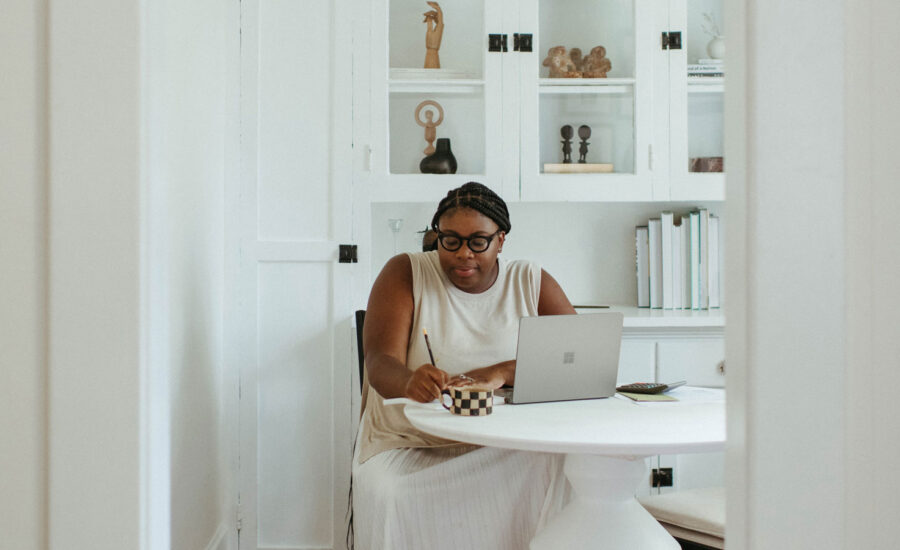 A woman sits at her at-home office, prepping her tax return, looking at the 2022 credits she may qualify for.