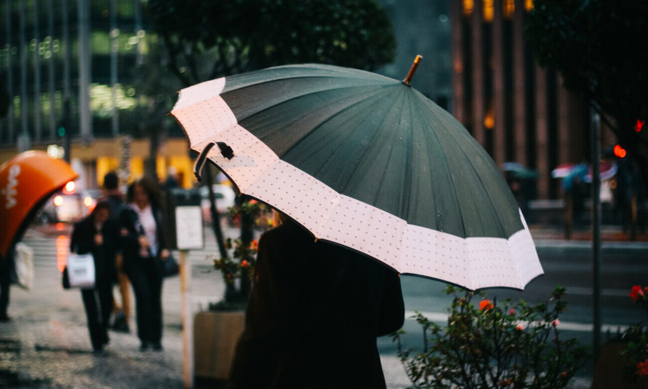 A woman walks on the street carrying an umbrella in preparation from the coming storm