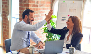 A woman meets with her accountant and high fives as she files her 2022 income tax return for Canada, showing that she accurately filed on deadline, with tax claims that suited her.