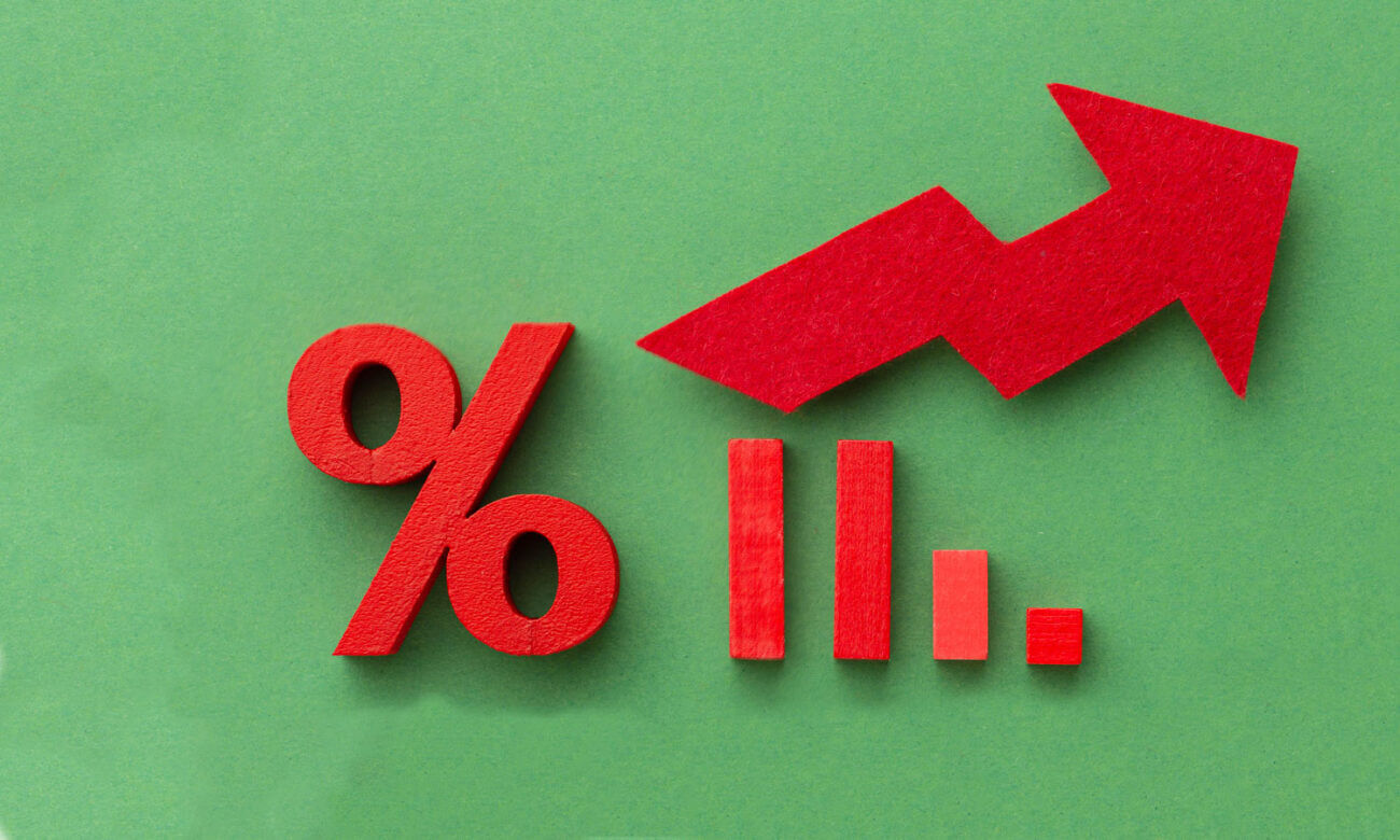 Felt cutouts of percentage sign and graph with an arrow going up in red and green, showing a look back at 2022 and inflation and BoC rate hikes