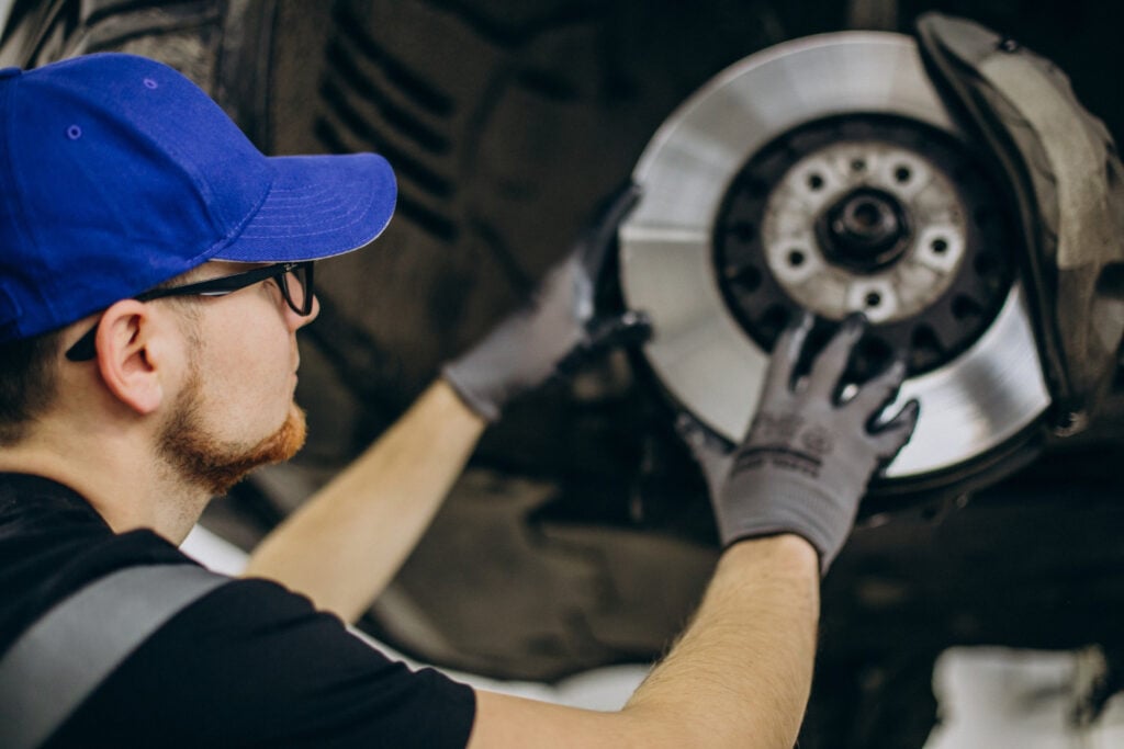 A mechanic installs a tire on a car