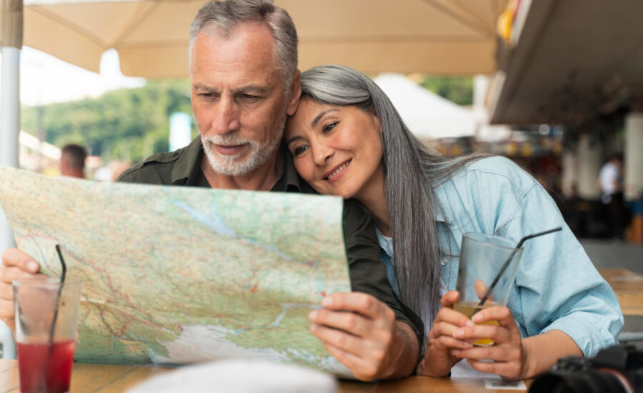 A middle-aged man and woman at a cafe, looking at a map