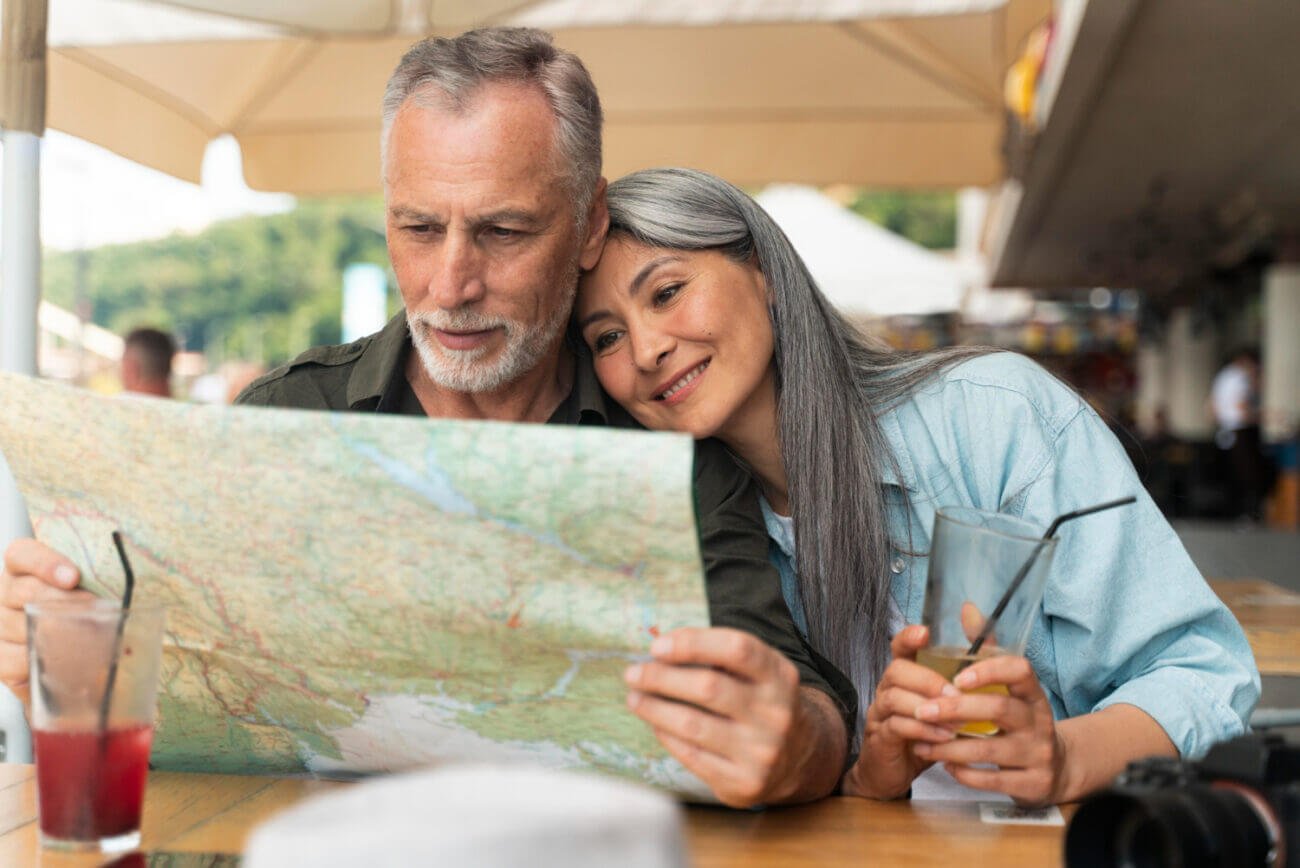 A middle-aged man and woman at a cafe, looking at a map