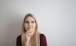 A woman rests her chin on her and looks up, pondering, What is financial psychology?