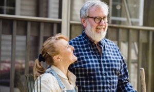 A man and woman in their 60s are happy about having extra money to invest