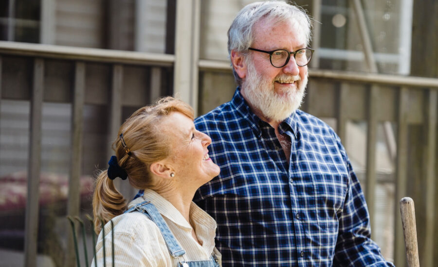 A man and woman in their 60s are happy about having extra money to invest