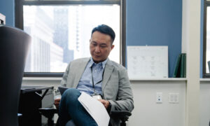 A man reads documents about his TFSA and other investments at work, as he plans his retirement.