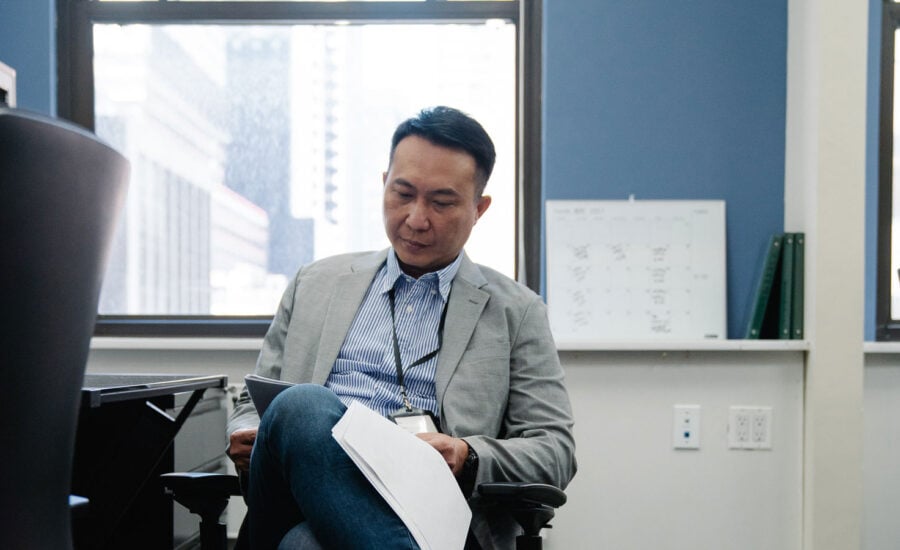 A man reads documents about his TFSA and other investments at work, as he plans his retirement.