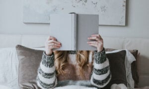 A woman reading a book to symbolize her learning about her money story