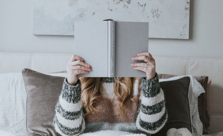 A woman reading a book to symbolize her learning about her money story