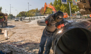 A photo of a welder working on a pipeline as we cover Canadian pipeline earnings