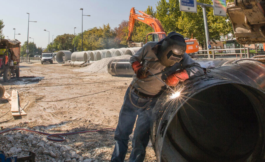 A photo of a welder working on a pipeline as we cover Canadian pipeline earnings